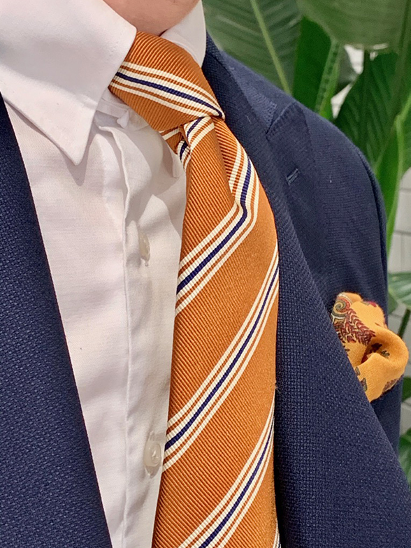 発色を活かしたオレンジ色のネクタイを添えて
